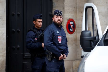 French police stand in front of the building where former French President Jacques Chirac was living in Paris