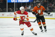 Calgary Flames' Andrew Mangiapane, left, chases the puck during the first period of an NHL hockey game against the Anaheim Ducks, Friday, Dec. 3, 2021, in Anaheim, Calif. (AP Photo/Jae C. Hong)