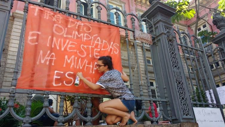 <span class="caption">A student spraying ‘take from the Olympics and invest in my school’, outside an occupied school in Rio.</span> <span class="attribution"><span class="source">https://www.facebook.com/ocupaamaro</span></span>