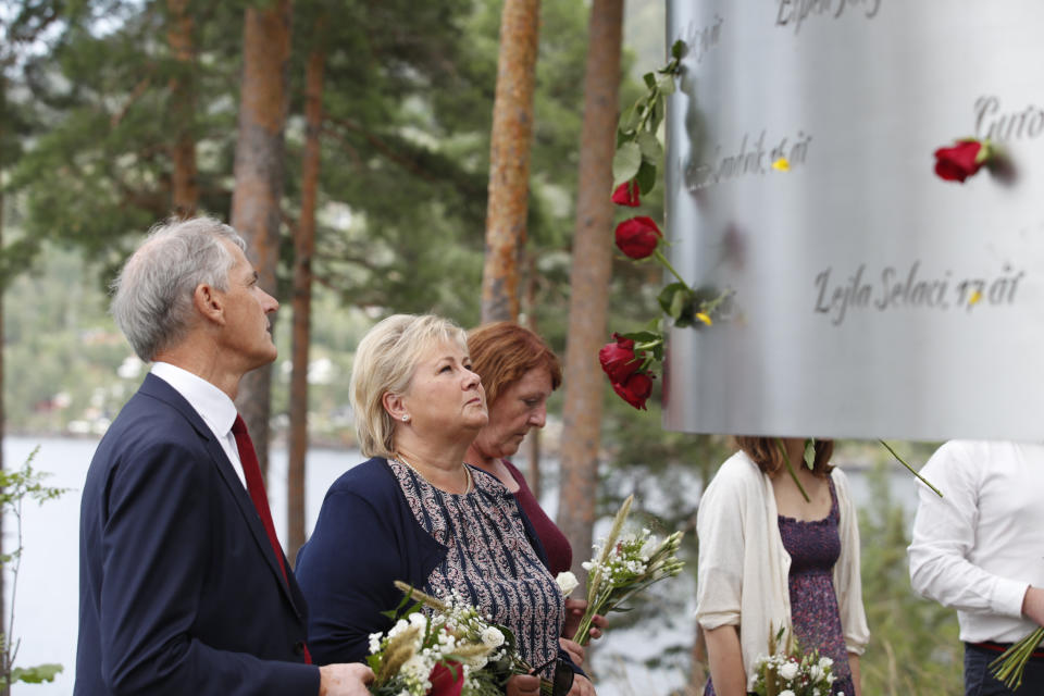 FILE - In this July 22, 2019 file photo, Norway's Prime Minister Erna Solberg, center, and leader of the Labour party Jonas Gahr Stoere, left, attend a memorial ceremony to mark the 8th anniversary of the shootings on Utoya Island, where sixty nine people were killed by Anders Breivik. At 3.25 p.m. on July 22, 2021, a ray of sun should have illuminated the first of 77 bronze columns on a lick of land opposite Utoya island outside Oslo. Over the next 3 hours and 8 minutes, it would have brushed each column in turn, commemorating every person killed by right-wing terrorist Anders Breivik. But on the ten-year anniversary of the terror, the memorial remains a construction site. (Terje Bendiksby/NTB Scanpix via AP, File)