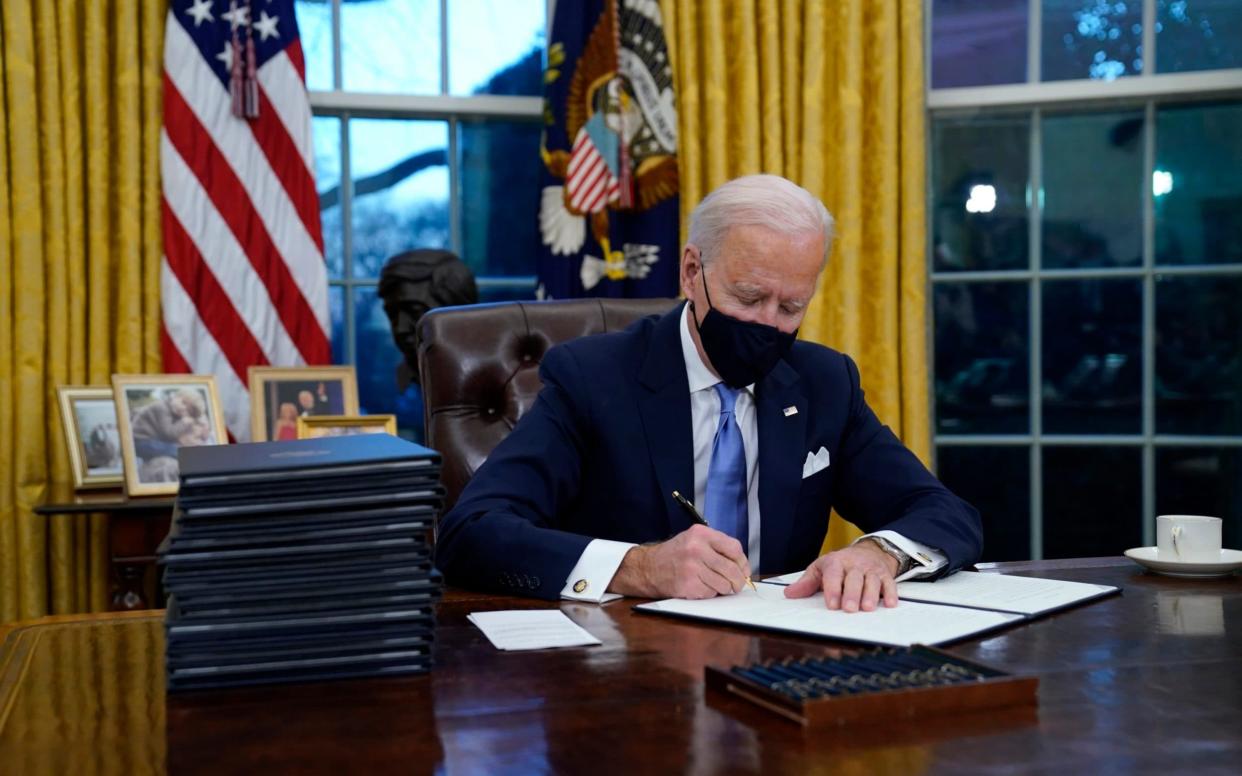 President Joe Biden signs his first executive order in the Oval Office of the White House - AP Photo/Evan Vucci