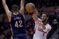 Portland Trail Blazers guard Evan Turner, right, passes the ball away from New Orleans Pelicans center Alexis Ajinca during the second half of an NBA basketball game in Portland, Ore., Wednesday, April 12, 2017. The Pelicans won 103-100. (AP Photo/Craig Mitchelldyer)