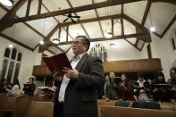 In this Sunday, Feb. 16, 2020, photo Baptist Pastor Clifford Maung, front, an immigrant from Myanmar, also known as Burma, sings a hymn with members of his congregation at the Overseas Burmese Christian Fellowship in Boston. Confusion, sorrow and outrage are rippling across some immigrant communities after the announcement of a Trump administration policy that is expected to all but shut down family-based immigration from four countries, including Myanmar. (AP Photo/Steven Senne)