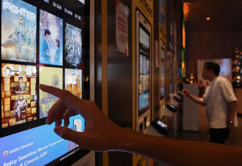 People buy movie tickets from a movie ticket kiosk at a cinema in Kuala Lumpur
