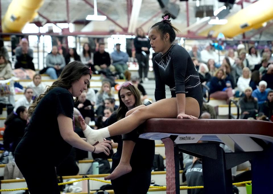 Warwick co-op gymnast Madison Long has her ankle taped after her first vaulting run.