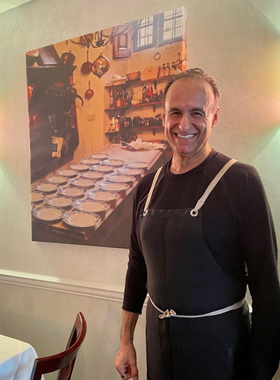 Adolfo Marisi, chef and owner of Lupa Ristorante in Berkeley Heights, in front of a photograph he took of Relais La Suvera in Tuscany, a famed restaurant where he once worked.