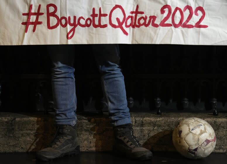 Activists protest against the World Cup which starts Sunday in Qatar, and called for a boycott in a demonstration outside the Qatar Embassy in Paris, Tuesday, Nov. 15, 2022. The protesters honored migrant workers who died during construction work for the tournament, and decried rights violations in Qatar. Qatar denies abuses. (AP Photo/Francois Mori)