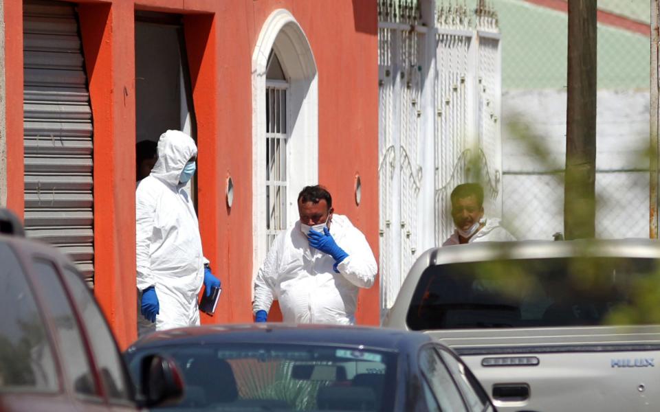 Forensics experts work at the house from where three film students went missing - AFP