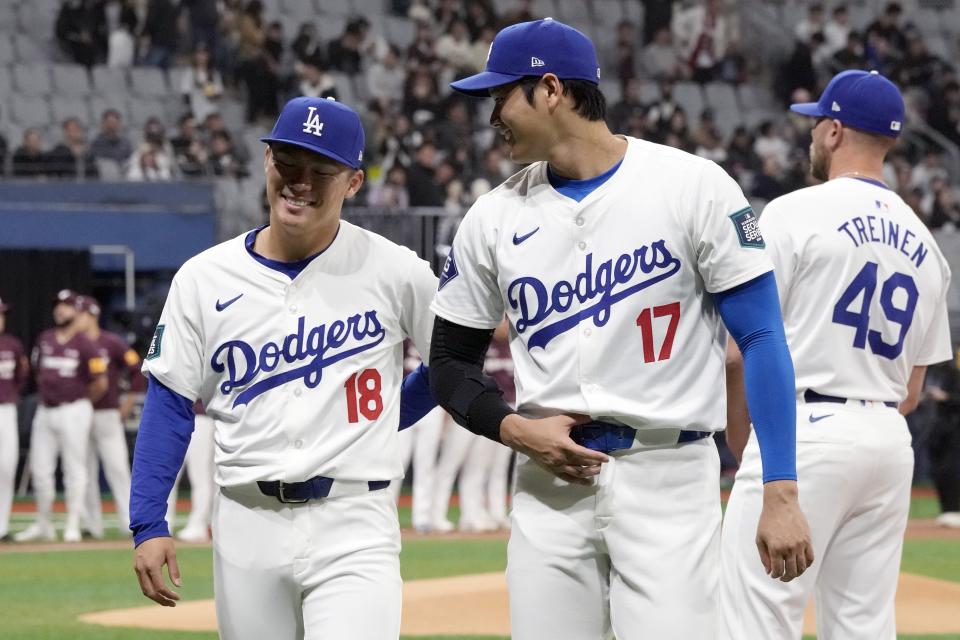 Los Angeles Dodgers' designated hitter Shohei Ohtani , right, and pitcher Yoshinobu Yamamoto, left, chat prior to the exhibition game between the Los Angeles Dodgers and Kiwoom Heroes at the Gocheok Sky Dome in Seoul, South Korea, Sunday, March 17, 2024. The Los Angeles Dodgers and the San Diego Padres will meet in a two-game series on March 20th-21st in Seoul for the MLB World Tour Seoul Series. (AP Photo/Ahn Young-Joon)