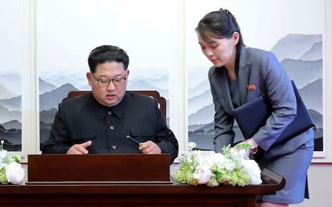 North Korean leader Kim Jong Un, left, signs a guest book next to his sister Kim Yo Jong - Credit: AP