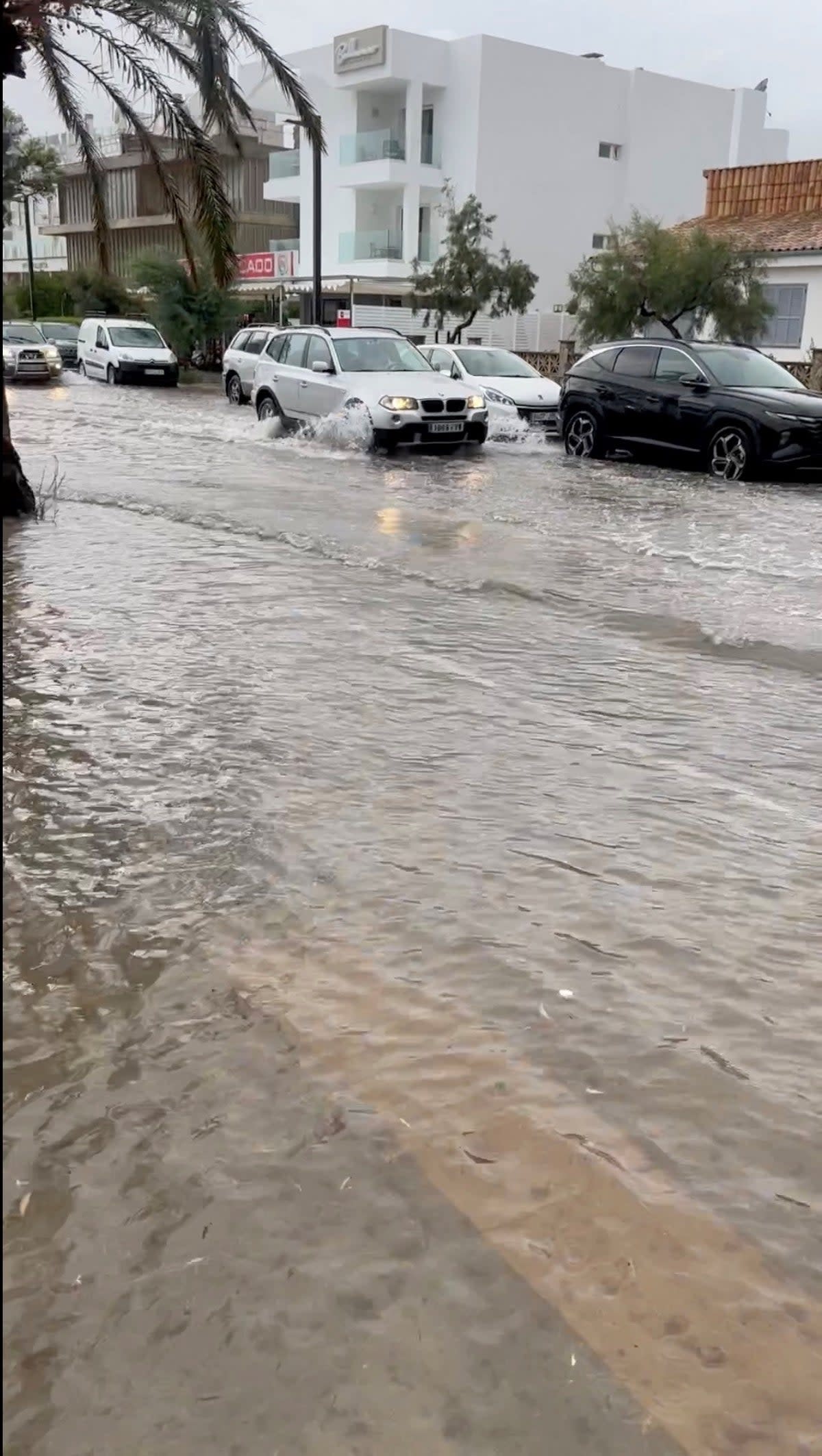 A view shows a car passing through a flooded road in Mallorca, Spain, August 27, 2023, in this screen grab obtained from a social media video (@gozzo82 via X via REUTERS)