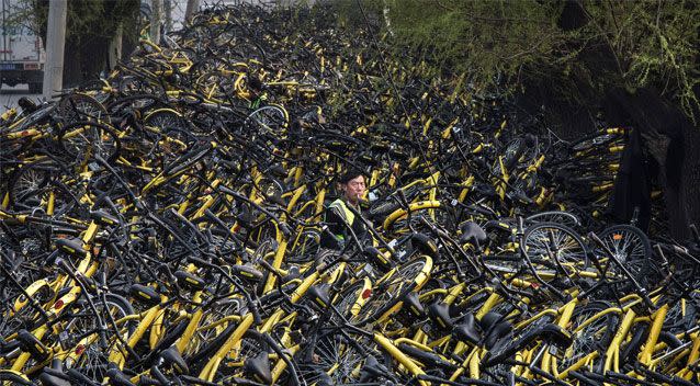 One worker struggles to keep on top of the escalating number of bikes. Source: Getty