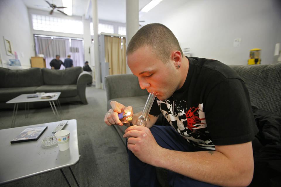 FILE - In this Oct. 19, 2009 file photo, Samuel Bagdorf of San Francisco, who suffers from anxiety disorders, lights his marijuana pipe at the San Francisco Medical Cannabis Clinic in San Francisco, Monday, Oct. 19, 2009. Law and order may soon be coming to the Wild West of Weed. A California lawmaker has introduced legislation to regulate the state’s free-wheeling medical marijuana industry, the farmers that grow the drug, the hundreds of storefront shops that sell it and especially the doctors who write recommendations allowing people to use it. (AP Photo/Eric Risberg, File)