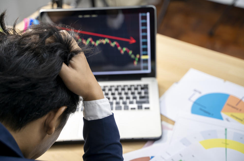 Stock trader tearing out his hair from despair, rear view