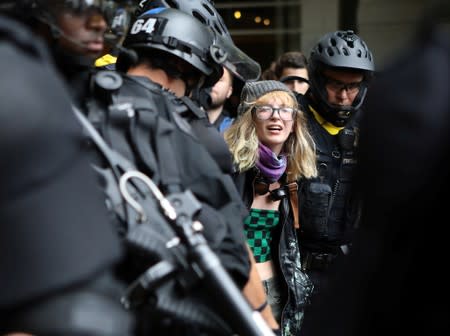 A counter-protester is detained by law enforcement after a Proud Boys rally in Portland, Oregon