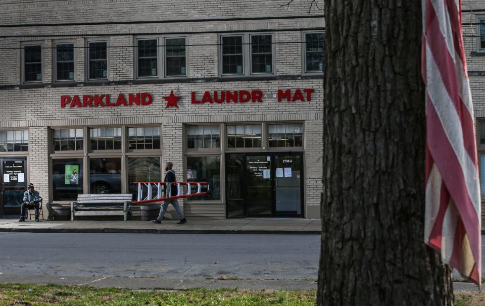 Jason Weaver sits near the entrance to the Parkland Laundromat on Dumesnil Street in West Louisville. Weaver, who works at the laundromat, said he remembers when that section of town had a thriving business district in the early 1960s. He sweeps the sidewalks around the intersection of Dumesnil and 28th Streets because "first impressions count." Weaver hopes more businesses come back to the area where he has lived his whole life. Dec. 16, 2021 