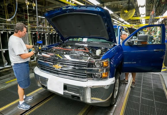 A blue Chevrolet Silverado 2500 HD is shown being attended by 2 workers on the assembly line at GM's Flint Assembly Plant in Flint, Michigan.