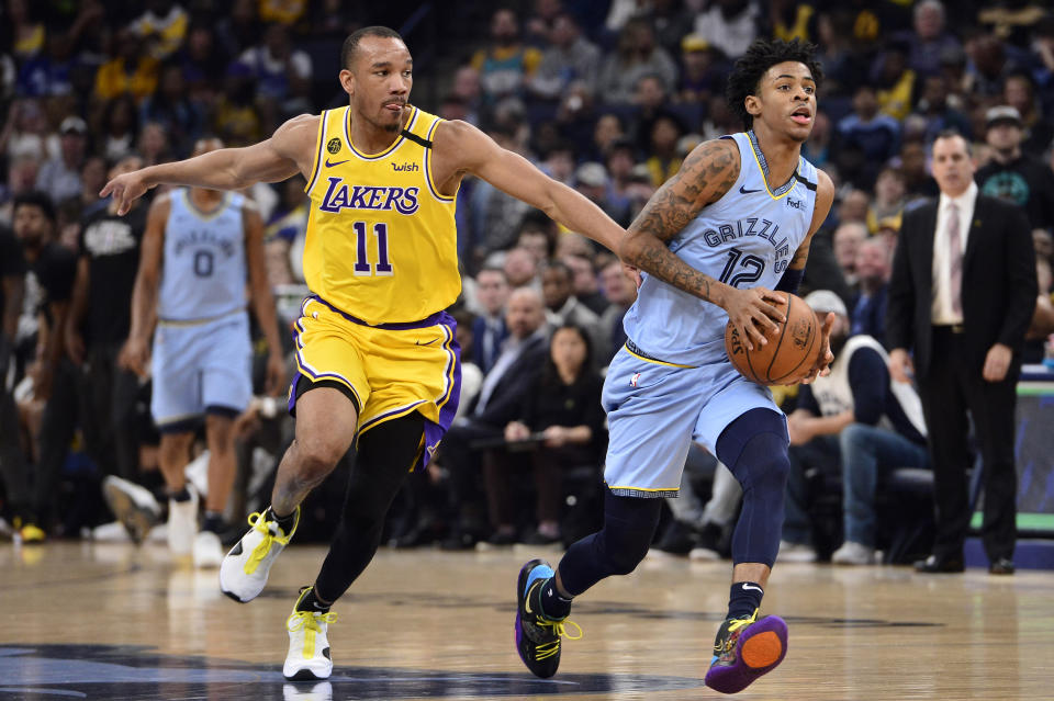 Memphis Grizzlies guard Ja Morant (12) drives ahead of Los Angeles Lakers guard Avery Bradley (11) in the second half of an NBA basketball game Saturday, Feb. 29, 2020, in Memphis, Tenn. (AP Photo/Brandon Dill)