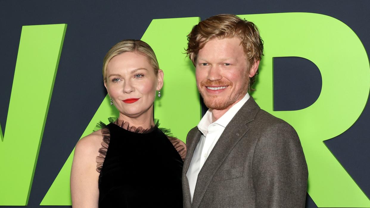 kirsten dunst standing next to jesse plemons at a film premiere red carpet