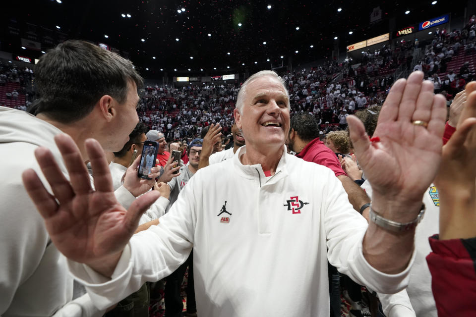 San Diego State head coach Brian Dutcher reacts with fans after San Diego State defeated Wyoming in an NCAA college basketball game to win the Mountain West Conference Saturday, March 4, 2023, in San Diego. (AP Photo/Gregory Bull)