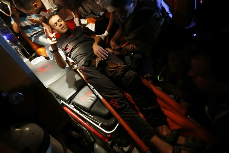 Palestinian paramedics carry away a wounded protester from a group calling themselves the "night confusion units" near the Israeli border east of Rafah in the southern Gaza Strip, on September 26, 2018