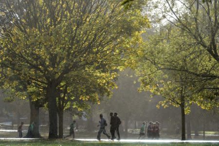 A fitness group runs in sunshine and rain in Victoria Park, as Storm Brian hits parts of the country, in London, Britain October 21, 2017. REUTERS/Mary Turner