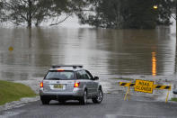 A car turns at a closed road in Richmond on the outskirts of Sydney, Australia, Monday, July 4, 2022. More than 30,000 residents of Sydney and its surrounds have been told to evacuate or prepare to abandon their homes on Monday as Australia's largest city braces for what could be its worst flooding in 18 months. (AP Photo/Mark Baker)