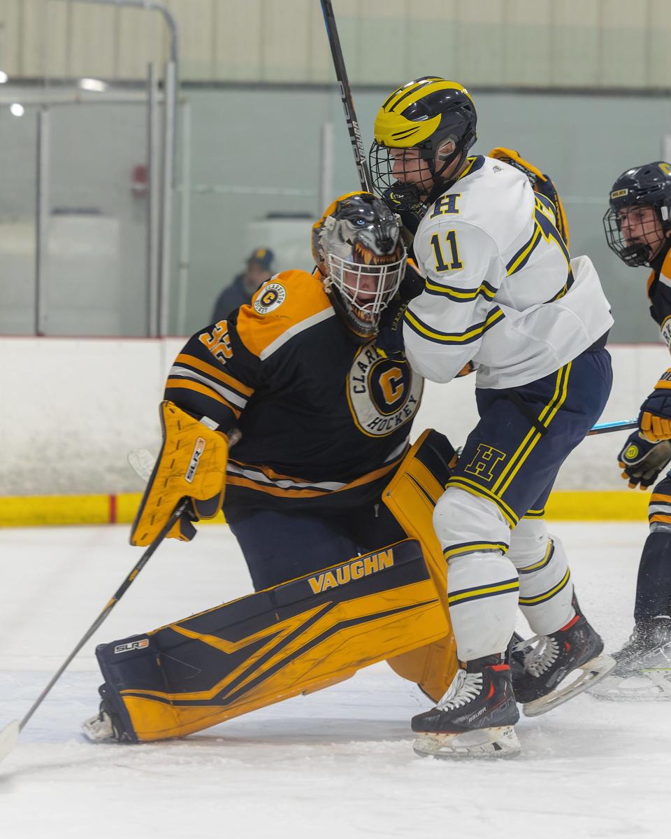 Hartland's Ben Pouliot collides with Clarkston goalie Calum Hartner during the Eagles' 6-1 victory in a regional championship game Wednesday, March 1, 2023.