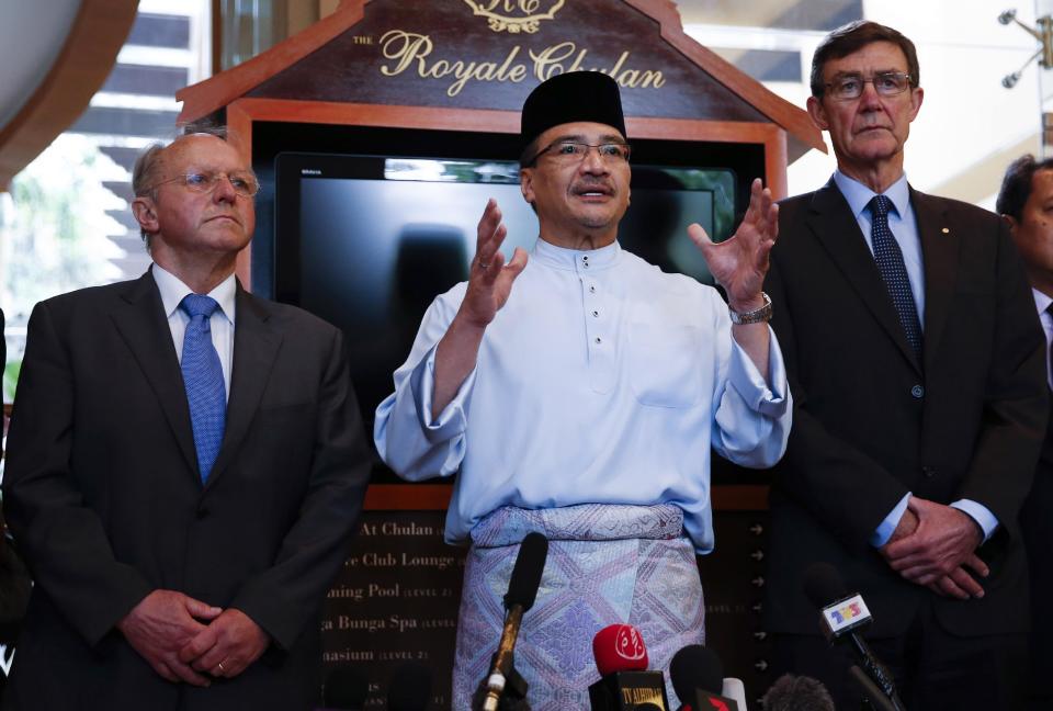 Malaysian Defense Minister and acting Transport Minister Hishammuddin Hussein, center, speaks to reporters as the chief coordinator of the Joint Agency Coordination Center (JACC) Angus Houston, right, and President of French Aviation Accident Investigation Bureau Jean-Paul Troadec listen in Kuala Lumpur, Malaysia, Friday, May 2, 2014. Air traffic controllers did not realize that Malaysia Airlines Flight 370 was missing until 17 minutes after it disappeared from civilian radar, according to a preliminary report on the plane's disappearance released Thursday by Malaysia's government. The government also released other information from the investigation into the flight, including audio recordings of conversations between the cockpit and air traffic control, the plane's cargo manifest and its seating plan. (AP Photo/Vincent Thian)