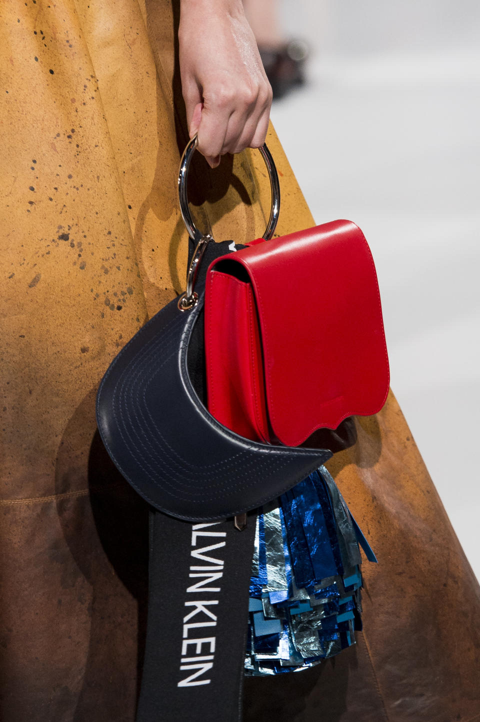 <p><i>Crimson bag with circular metal handle from the SS18 Calvin Klein collection. (Photo: ImaxTree) </i></p>