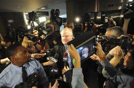 Toronto Mayor Rob Ford (C) is surrounded by the media as he returns to a city council meeting after a lunch break in Toronto November 15, 2013. REUTERS/Jon Blacker