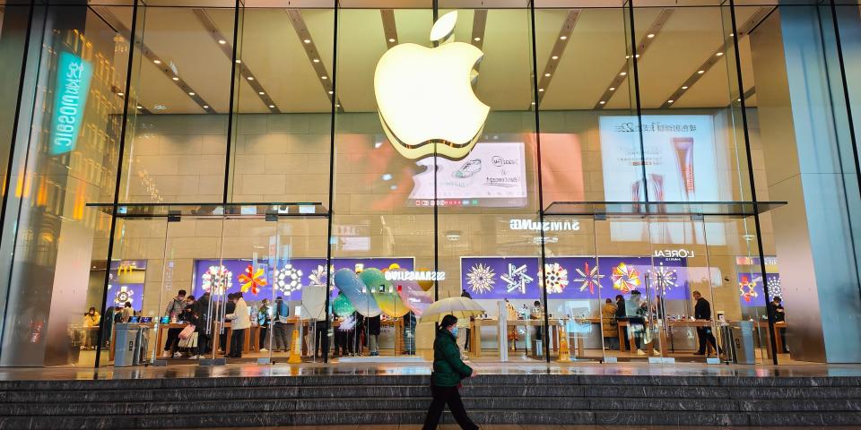 citizens pass an Apple store on Nanjing Road Pedestrian street in Shanghai, China, December 16, 2022