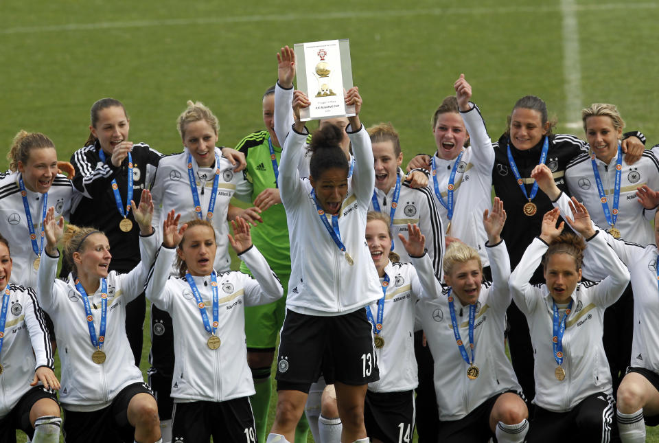 Germany's captain Celia Sasic, center, lifts up the trophy to celebrate with teammate after winning the women's soccer Algarve Cup at the Algarve stadium, outside Faro, southern Portugal, Wednesday, March 12, 2014. (AP Photo/Francisco Seco)