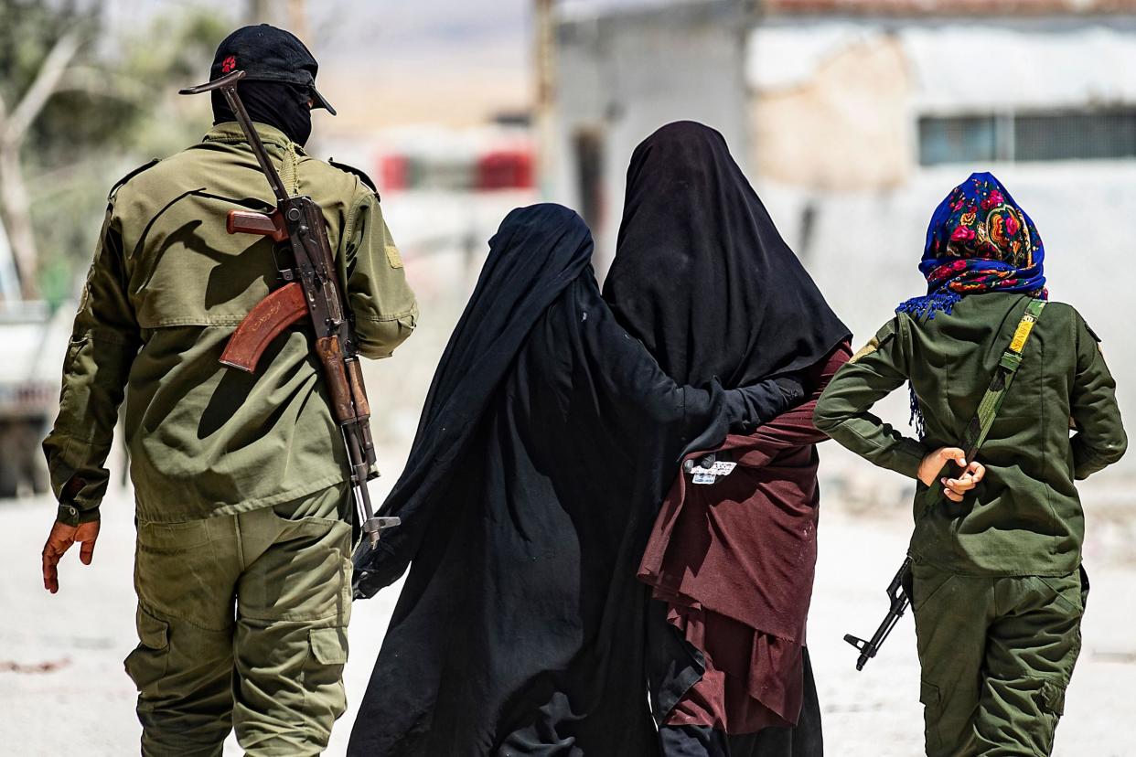 An internal security patrol escorts women, reportedly wives of Islamic State (IS) group fighters, in the al-Hol camp in al-Hasakeh governorate in northeastern Syria: AFP