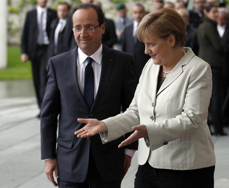 German Chancellor Angela Merkel, right, welcomes the President of France, Francois Hollande, left, with military honors at the chancellery in Berlin, Germany, Tuesday, May 15, 2012. France's new President Francois Hollande has arrived in Berlin for a keenly anticipated first meeting with German Chancellor Angela Merkel. His arrival was delayed by one hour after the presidential plane suffered a mid-air lightning strike and had to return to Paris to be swapped for another. Hollande will hold talks with chancellor Angela Merkel that are expected to be dominated by Europe's debt crisis. (AP Photo/Michael Sohn)