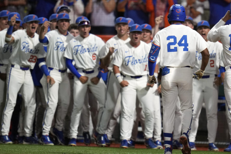 Florida's Josh Rivera (24) celebrates with teammates after hitting a two-run home run against South Carolina during the first inning of an NCAA college baseball tournament super regional game Friday, June 9, 2023, in Gainesville, Fla. (AP Photo/John Raoux)