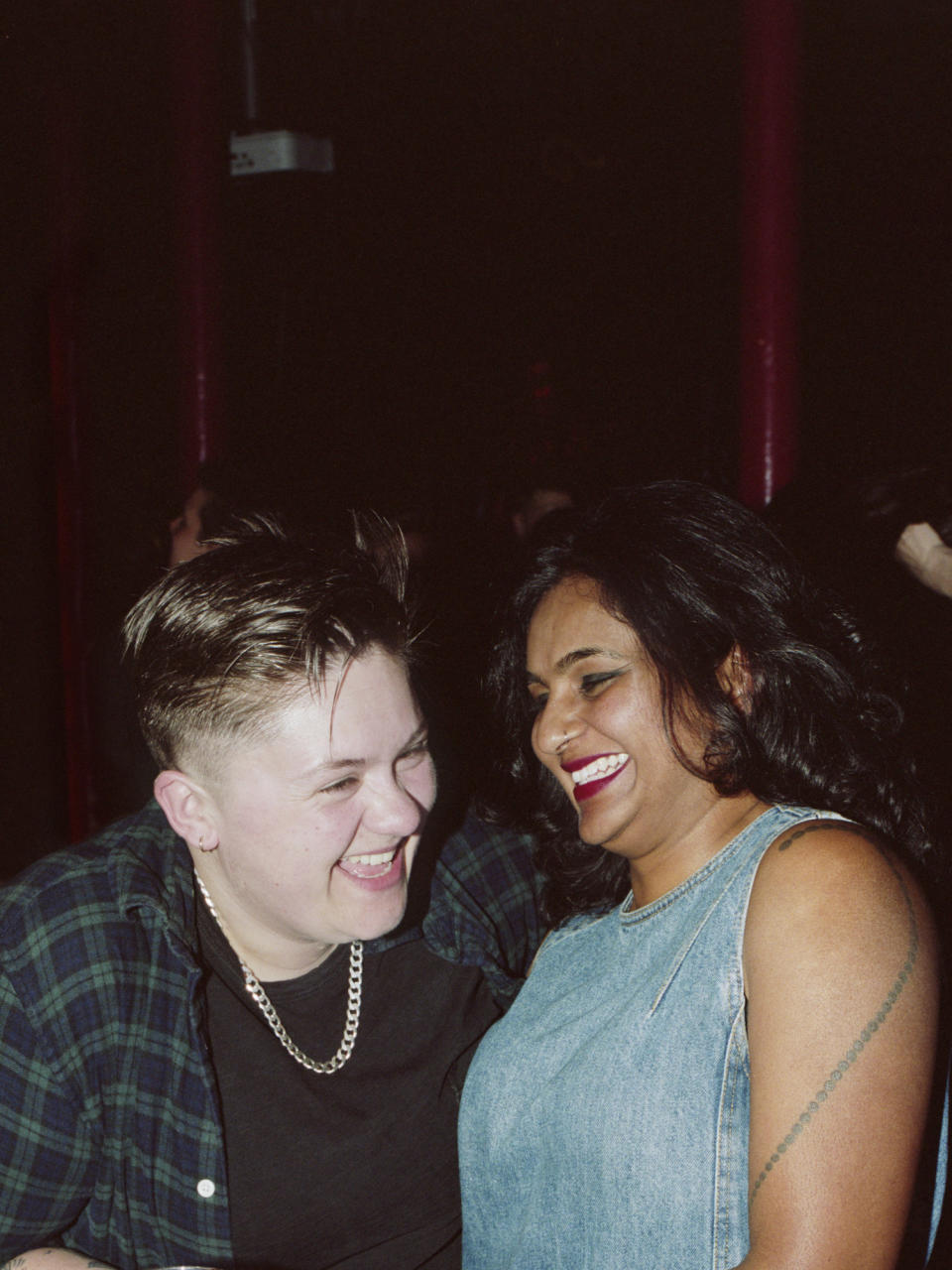 two friends in a bar laughing