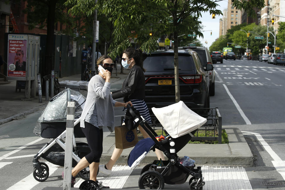 NEW YORK, NEW YORK - MAY 18: Women wearing protective masks cross the street with baby carrieges as some restrictions begin to lift during the coronavirus pandemic on May 18, 2020 in New York City. COVID-19 has spread to most countries around the world, claiming over 320,000 lives and infecting over 4.8 million people (Photo by John Lamparski/Getty Images)