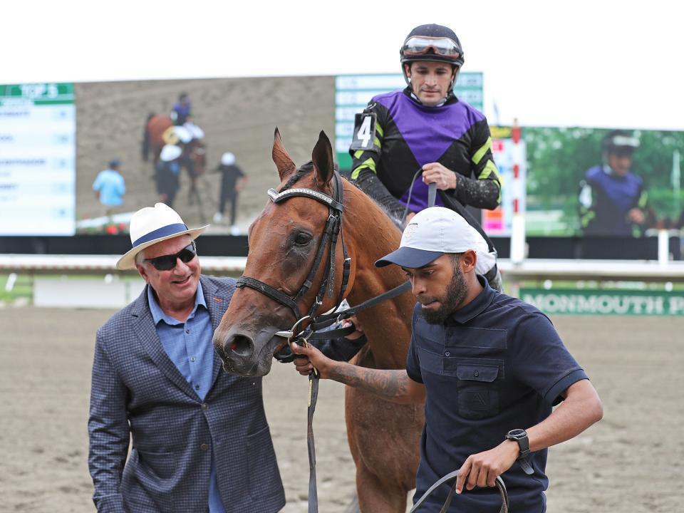 Owner John Guarnere (left) of Imaginary Stables walks Howgreatisnate, with Jairo Rendon riding, into the winners circle after winning the $100,000 Long Branch Stakes on Opening Day at Monmouth Park Racetrack in Oceanport, N.J.