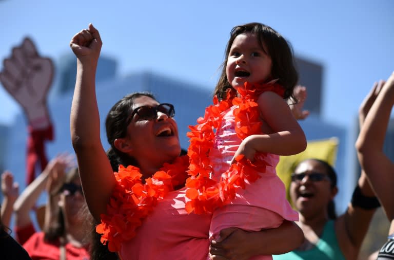 A mother and daughter cheer at the "A Day Without a Woman" rally honoring International Women's Day, in Los Angeles, California