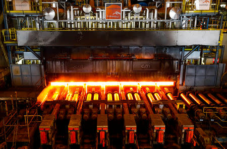 FILE PHOTO: A red-hot steel plate passes through a press at the ArcelorMittal steel plant in Ghent, Belgium, May 22, 2018. REUTERS/Yves Herman/File Photo