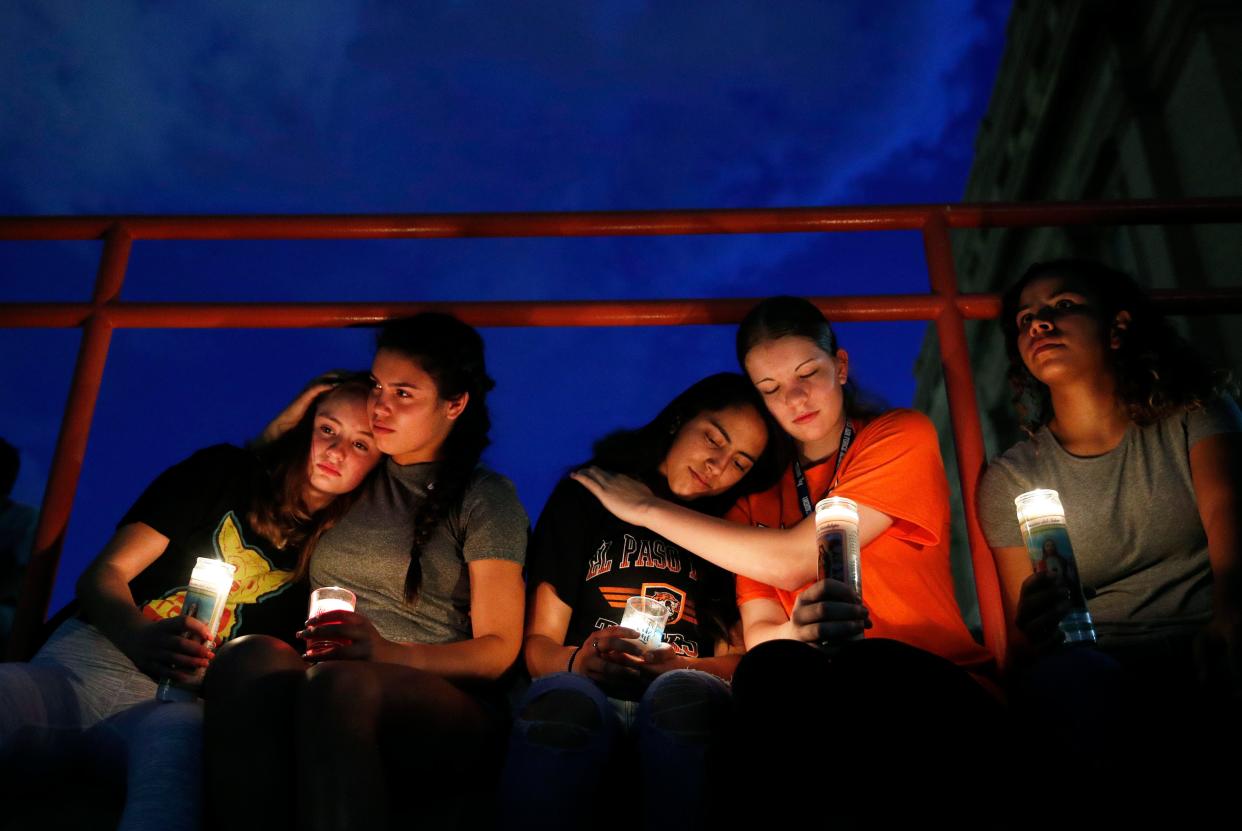 Students comfort each other during a vigil for victims of the El Paso Walmart shooting on Saturday.