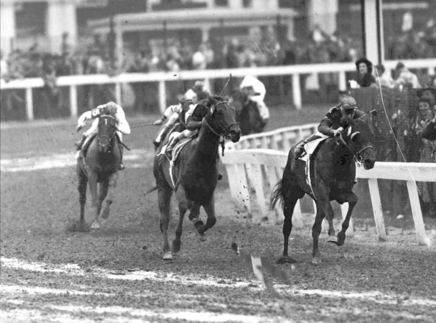 FILE – Citation, center, with Eddie Arcaro in the saddle, comes up on Coaltown, right, during the Kentucky Derby in Louisville, Ky., May 1, 1948. America’s longest continuously held sporting event turns 150 years old Saturday. The Kentucky Derby has survived two world wars, the Depression and pandemics, including COVID-19 in 2020, when it ran in virtual silence without the usual crowd of 150,000.(AP Photo/File)