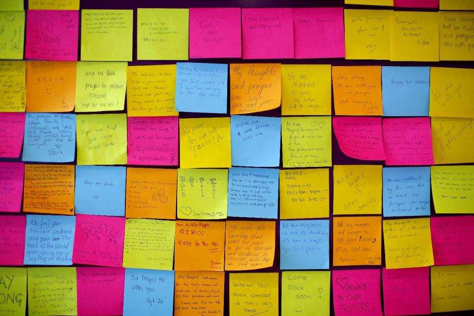 Messages for passengers on board the missing AirAsia flight 8501 are placed on a board at Changi International Airport, Tuesday, Dec. 30, 2014 in Singapore. Searchers combing the Java Sea to find and recover debris and bodies from the AirAsia jet that crashed there have the advantage of working in much shallower waters than those found in the open ocean, but also face challenges that include monsoons, murkiness and trash. (AP Photo/Wong Maye-E)