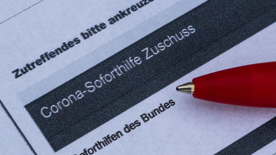 Ein Stift liegt auf einem Antrag für den Corona-Soforthilfe-Zuschuss.