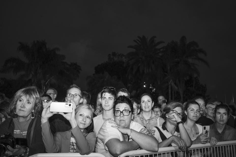 Spectators watch actors arriving on the red carpet at the 75th international film festival, Cannes, southern France, Monday May 23, 2022. (AP Photo/Petros Giannakouris)