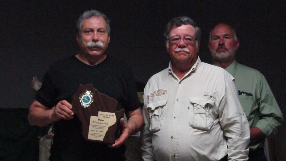 Dan Cichantek (from left), enshrinee, with Terry Busse representing Manitowoc Gun Club and Larry Bonde, Hall of Fame emcee.