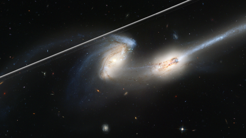A satellite streak in the foreground of a Hubble image of interacting galaxies NGC 4676.