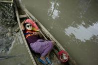 A resident rests in a boat floating in floodwaters in Kalay, upper Myanmar's Sagaing region on August 3, 2015