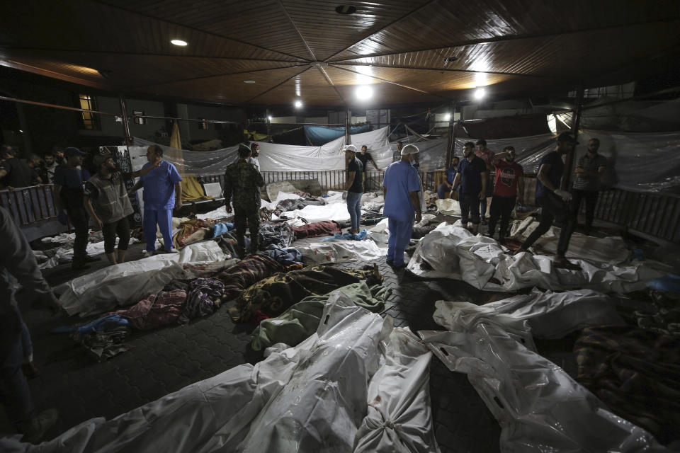 Bodies of Palestinians killed by an explosion at the Ahli Arab hospital are gathered in the front yard of the al-Shifa hospital, in Gaza City, central Gaza Strip, Tuesday, Oct. 17, 2023. The Hamas-run Health Ministry says an Israeli airstrike caused an explosion that killed hundreds at the Ahli Arab hospital, but the Israeli military says it was a misfired Palestinian rocket. (AP Photo/Abed Khaled)